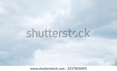 The photo showcases a breathtaking view of white and gray clouds floating in the sky. The composition captures the beauty and vastness of the heavens above. 
