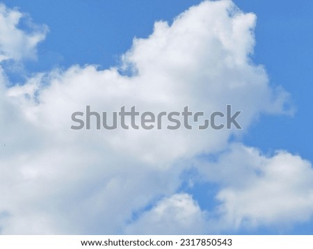 The sky is adorned with pristine white clouds floating against  backdrop of vibrant blue. These fluffy, cotton-like clouds create serene and peaceful atmosphere, enhancing  beauty of natural world.
