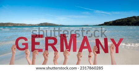 People Or Persons Hands Building English Word Germany. Summer Ocean, Sea And Beach As Background.