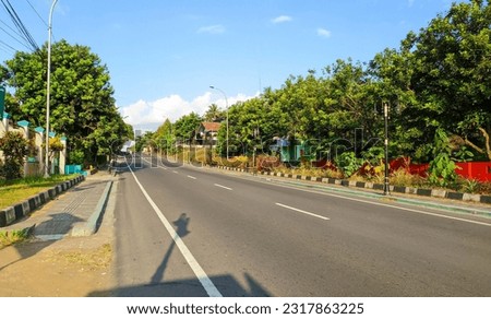 view of asphalt road with trees in indonesia Royalty-Free Stock Photo #2317863225