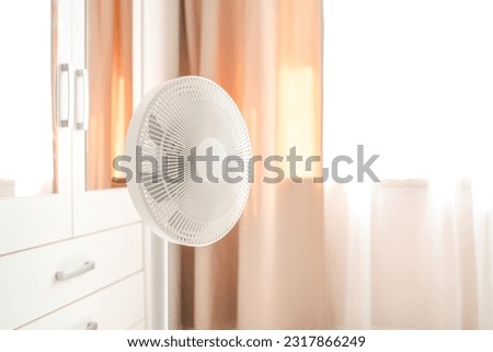 White desktop electric fan on light white room. Minimal concept with copy space. Royalty-Free Stock Photo #2317866249