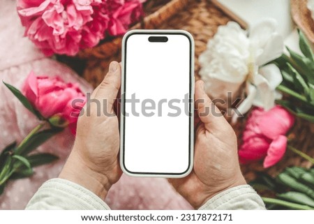 Mobile phone and spring flower pink peonies on the pink background. Theme of love, mother's day, women's day flat lay.