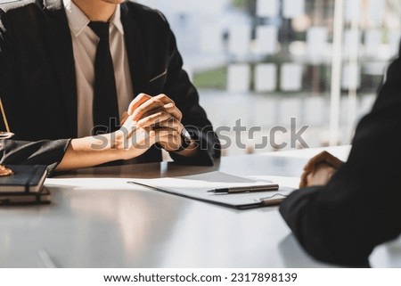 Lawyer is explaining the terms of the legal contract document and asking the client to sign it properly. Legal counsel and legal proceedings consulting services. Royalty-Free Stock Photo #2317898139