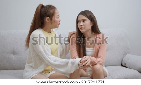 Two women talking about problems at home. Asian women embrace to calm their sad best friends from feeling down. Female friends supporting each other. Problems, friendship, and care concept Royalty-Free Stock Photo #2317911771