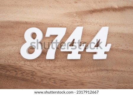 White number 8744 on a brown and light brown wooden background.