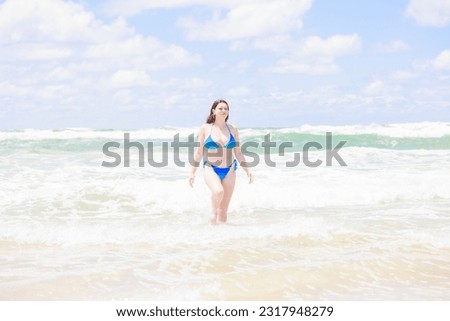 Caucasian woman in swimsuit entering the sea