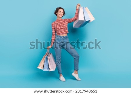 Full length photo of shiny sweet woman dressed pink rising bargains smiling isolated blue color background