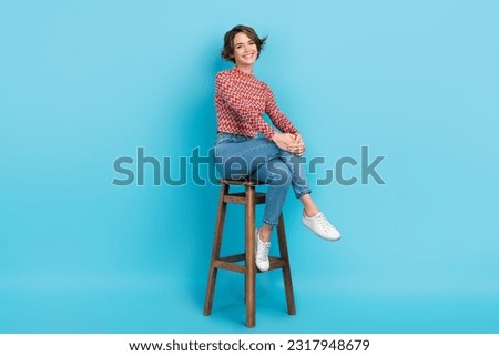 Photo adorable confident lady sit high bar chair order drinks bartender wear shirt pants sneakers isolated blue color background