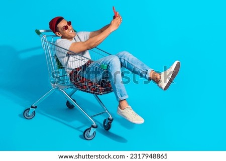 Photo of cool funky guy dressed grey t-shirt driving tray recording video vlog modern device isolated blue color background