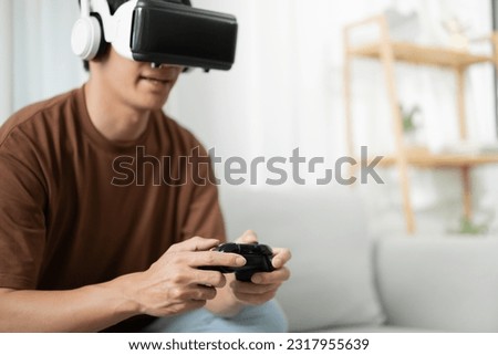 Young Asian man gamer wearing virtual reality touching air during the VR experience  Future home technology player hobby playful enjoyment concept
