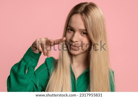 I am watching you. Young confident caucasian woman pointing at her eyes and camera, show I am watching you gesture, spying on someone. Pretty teenager girl isolated alone on pink studio background Royalty-Free Stock Photo #2317955831