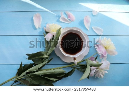Coffee for breakfast with flowers on a blue table