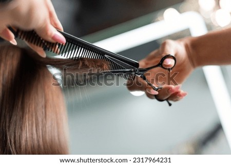 close up of scissors and professional comb, salon hair tools, cropped view of hairdresser cutting short brunette hair of female client, beauty worker, haircut, salon job, beauty industry Royalty-Free Stock Photo #2317964231
