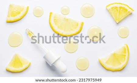 Drops of cosmetic serum and lemon slices. White background. Skin care product Royalty-Free Stock Photo #2317975949