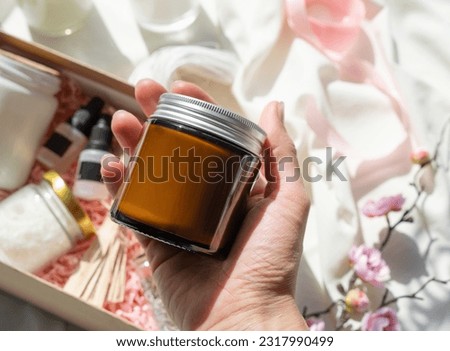 hand holding candle DIY gift box with soy wax, candle, wickes and essential oil for candle crafting. Hobbies and small business. Mockup