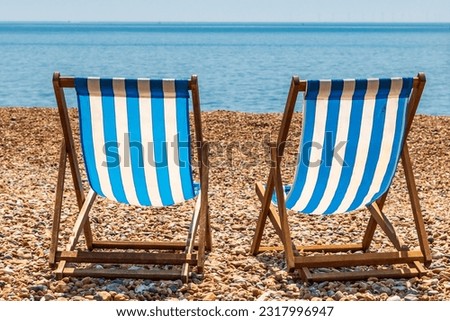 Two empty deck chairs on brighton Beach, on a sunny summer's day Royalty-Free Stock Photo #2317996947