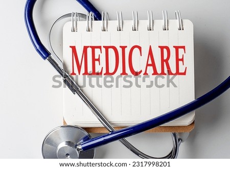 Medicare word on a notebook with medical equipment on background Royalty-Free Stock Photo #2317998201