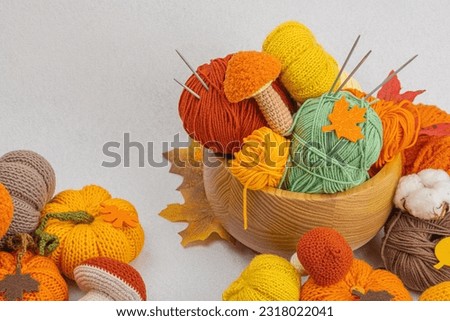 Set of clew of thread for knitting. Crocheted mushrooms, pumpkins, handmade, autumn hobby concept. Props and special craft tools on light stone concrete background, copy space Royalty-Free Stock Photo #2318022041