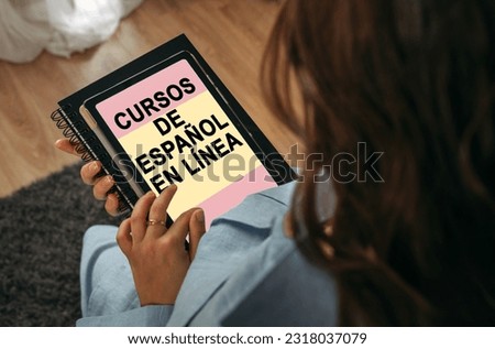 Online learning concept. A woman holds a tablet in her hands on the screen of which it is written - Online learning Spanish. The inscription is in Spanish.