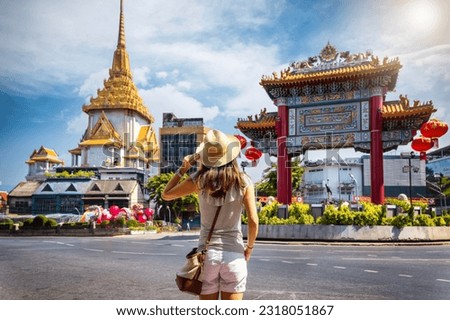 A tourist woman on sightseeing tour stands in front of the Chinatown Gate at the famous Yaowarat Road, Bangkok, Thailand Royalty-Free Stock Photo #2318051867