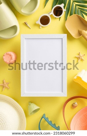 Leisure time with kids on the beach concept. Top vertical view photo of empty wooden frame with child toys for sand, slippers, panama and sunglasses, marine shells on yellow isolated background with c