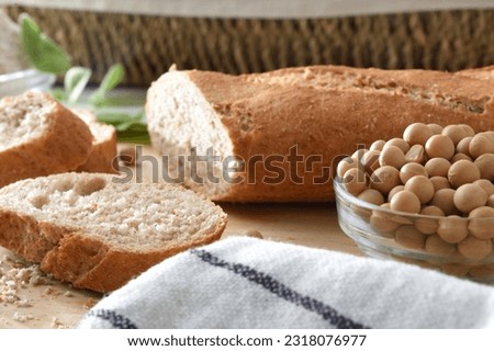 Detail of soy flour bread and grains on wooden bench in a kitchen. Front view. Royalty-Free Stock Photo #2318076977