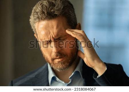 Man with sinus headache, tension or cluster headache, close up portrait. Head pain concept. Cephalalgia and migraine. Migraine symptoms. Chronic headaches. Headache triggers. Royalty-Free Stock Photo #2318084067