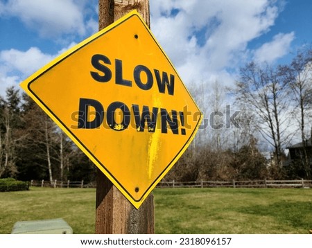 Slow down sign by the road near school area