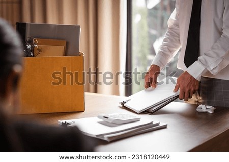Desperate office manager gathering personal stuff into the box. Fired from job concept. Royalty-Free Stock Photo #2318120449