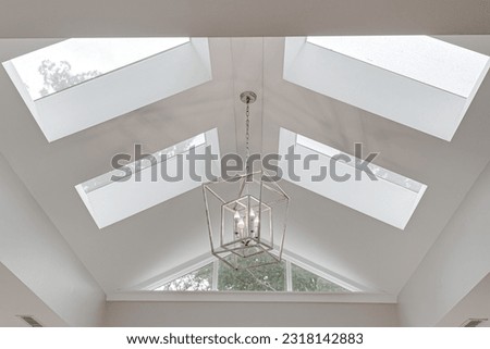 Minimal Bright Modern Skylight Vaulted Ceiling with Silver Metal Double Box Chandelier in Luxury Interior Royalty-Free Stock Photo #2318142883