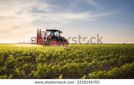 Tractor spraying pesticides on soybean field  with sprayer at spring Royalty-Free Stock Photo #2318146703