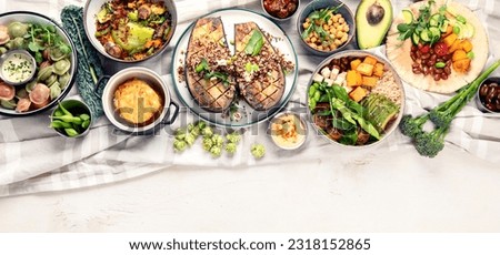 Fresh and healthy vegan table with chickpea, buddha bowl, pumpkins, broccoli, quinoa, sprout and other. Light background. Top view. Panorama with copy space.