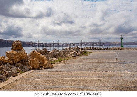 Rocks on the Adriatic coast of Croatia in the town of Karlobag in Lika-Senj county, late spring. Looking towards Otok Pag island Royalty-Free Stock Photo #2318164809