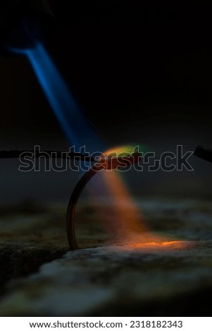 soldering jeweller ring. Picture of colorful flame and product close up.