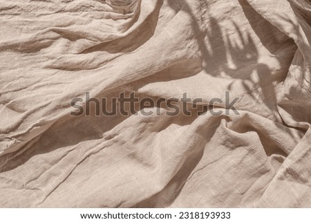 Abstract neutral background, crumpled draped linen fabric texture on a sun light with soft shadows, aesthetic sustainable bohemian backdrop, copy space