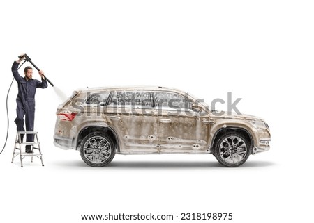 Man in a uniform standing on a ladder and washing a vehicle isolated on white background