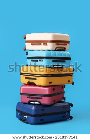 Stack of suitcases on blue background Royalty-Free Stock Photo #2318199141
