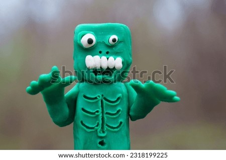 A figure of a funny monster. A toy green zombie.