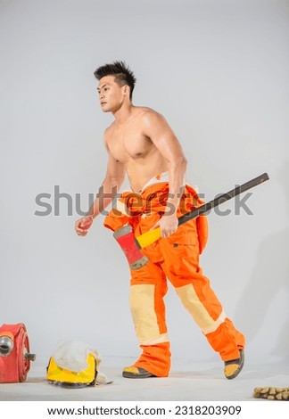 Professional firefighter confidently holds the iron axe a symbol of his preparedness and expertise in handling emergency situations.