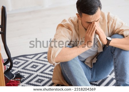 Young man having panic attack in office Royalty-Free Stock Photo #2318204369