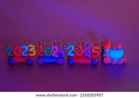 A toy train made of plasticine with the numbers 2023, 2024, 2025. A festive event. Christmas and New Year. Calendar date.