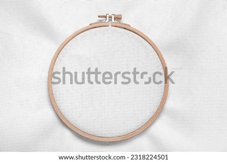 Wooden embroidery hoop with canvas as background Royalty-Free Stock Photo #2318224501