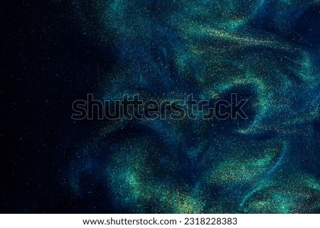 Various stains and overflows of gold particles in blue fluid with green tints. Golden particles dust and smooth defocused background. Liquid iridescent shiny backdrop with depth of field. Royalty-Free Stock Photo #2318228383