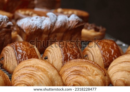 Close-up of fresh and beautiful french pastries (croissants, pains au chocolat) in a bakery showcase