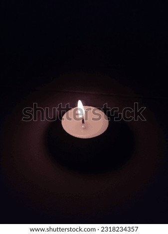 A small circular candle that glows in the dark