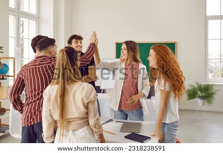 Nice job. Cheerful college students high five each other celebrating good exam results or high grade. Teenage girls and boys celebrate success in class. Concept of education and teamwork. Royalty-Free Stock Photo #2318238591