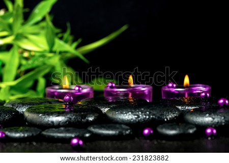 spa still life of zen basalt stones with drops, lilac candles, beads and bamboo