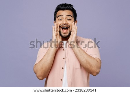 Young Indian man he wears pink shirt white t-shirt casual clothes scream sharing hot news about sales discount with hands near mouth isolated on plain pastel light purple background studio portrait Royalty-Free Stock Photo #2318239141