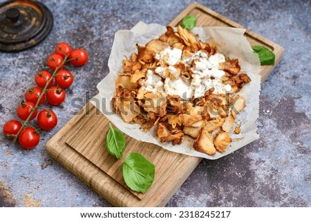  Portion of Spicy  kebab  Chicken  duner  gyros with french fries and garlic sauce  on  wooden board