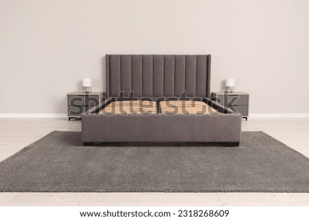 Comfortable bed with storage space for bedding under slatted base in room Royalty-Free Stock Photo #2318268609